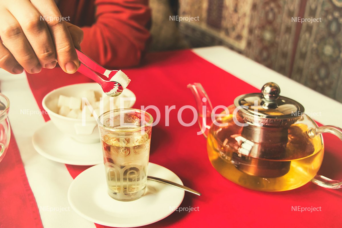 man puts a sugar cube in tea, restaurant, oriental style example image 1