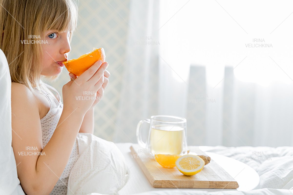 Sick girl in bed. Cup of flu drugs. Tea, orange,lemon,ginger example image 1