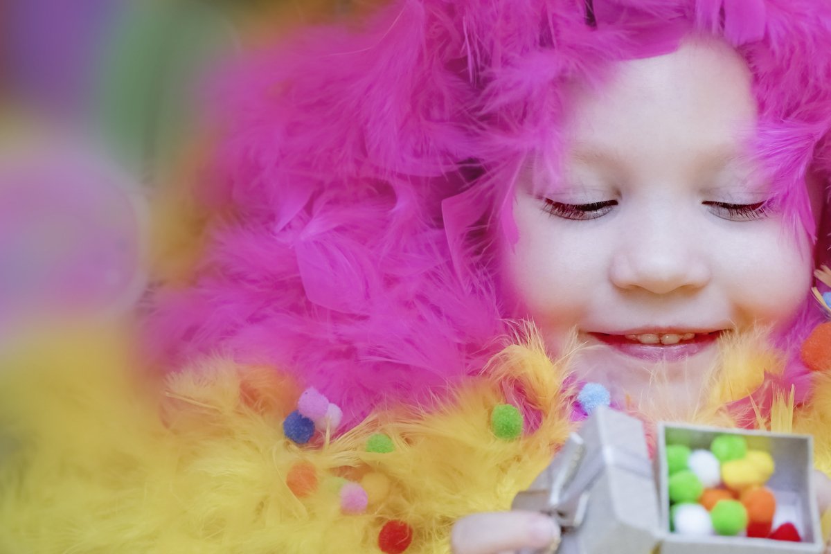 A little girl lies in a blurred festive setting. Birthday example image 1