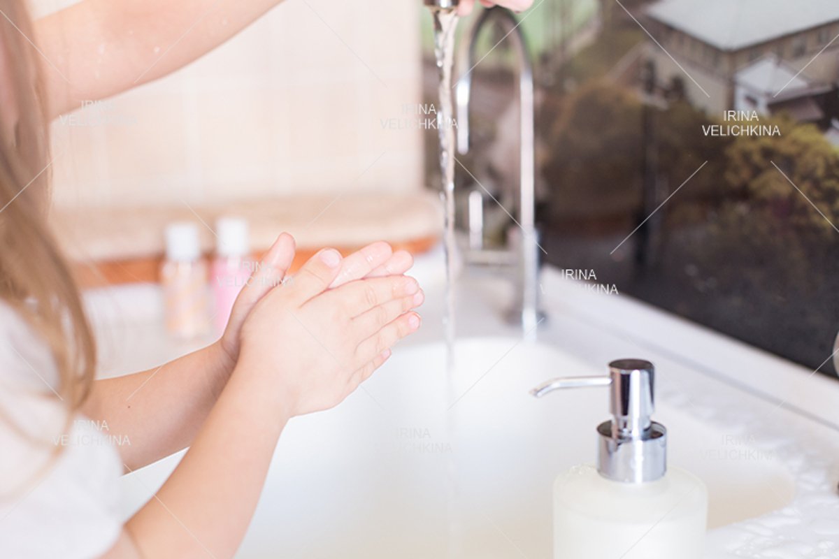 Girls wash their hands in the sink with soap in the foam example image 1