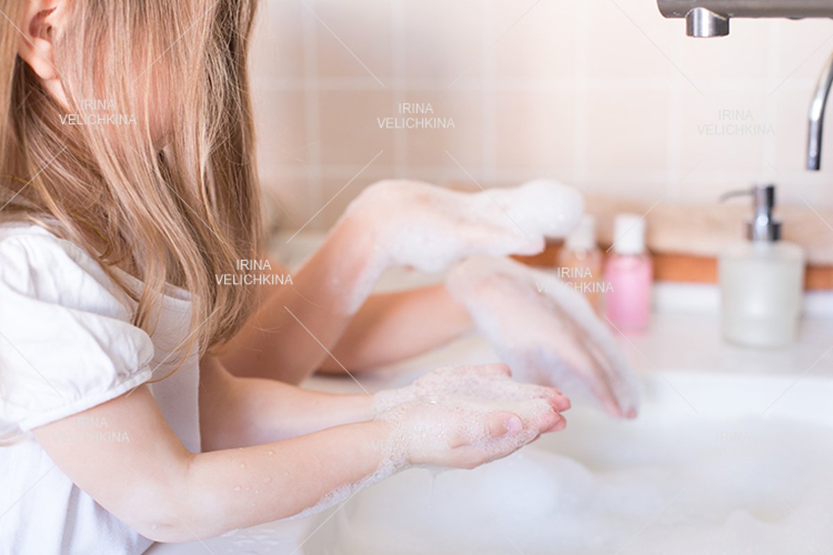 Girls wash their hands in the sink with soap in the foam example image 1
