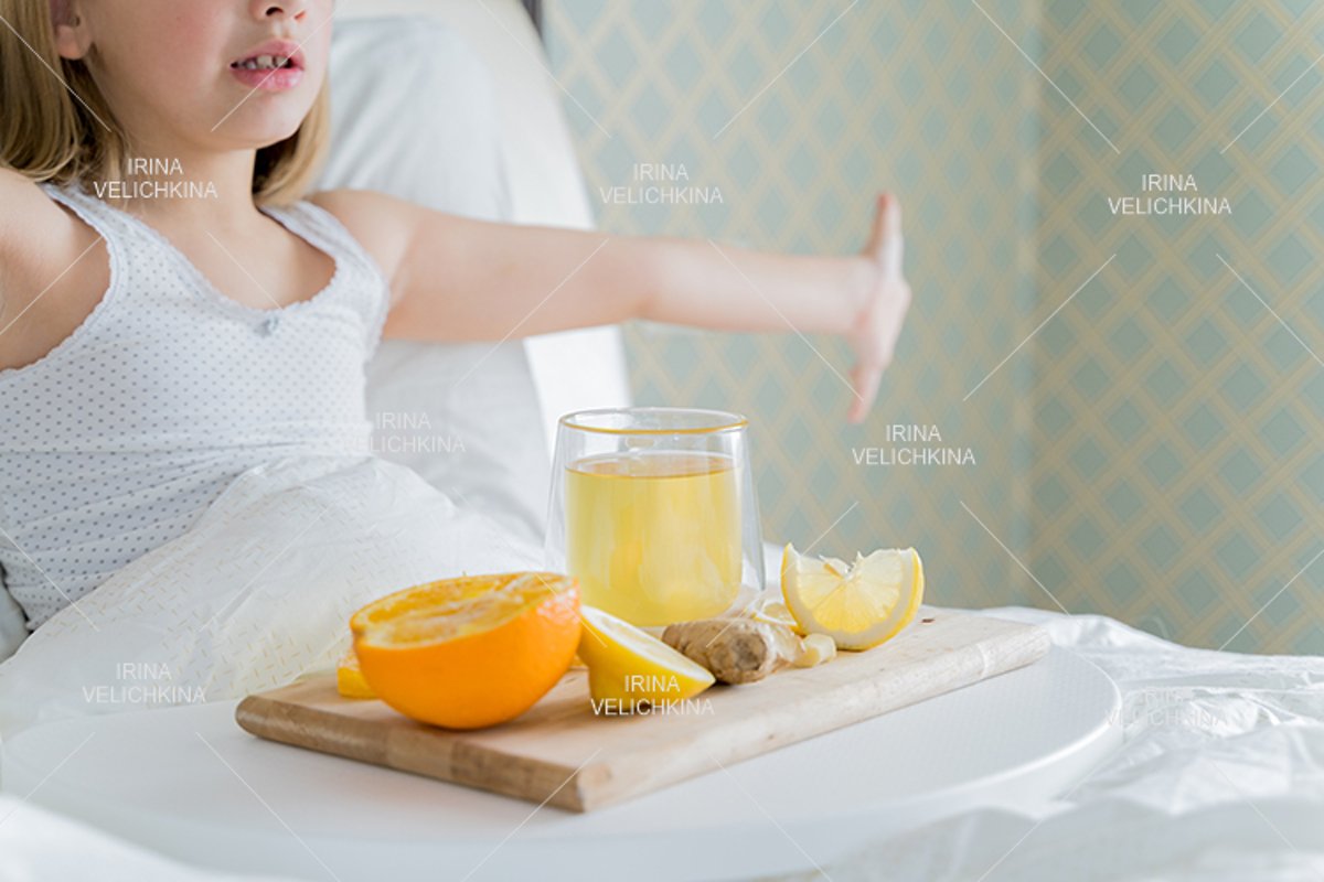Sick girl in bed. Cup of flu drugs. Tea, orange,lemon,ginger example image 1