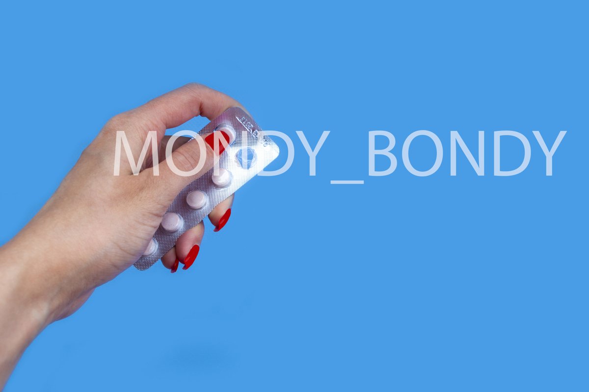 Pack of pills in hand on blue background example image 1