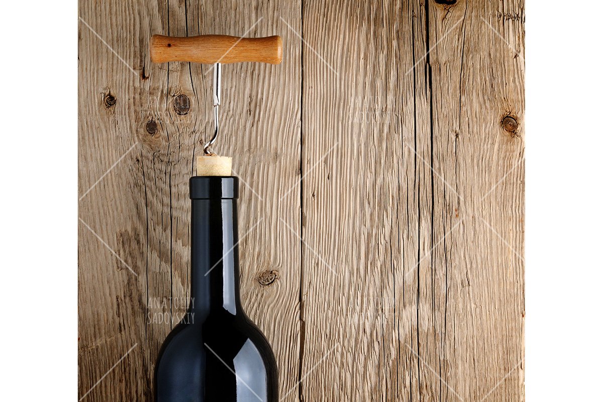 Bottle of wine with corkscrew on wooden background example image 1