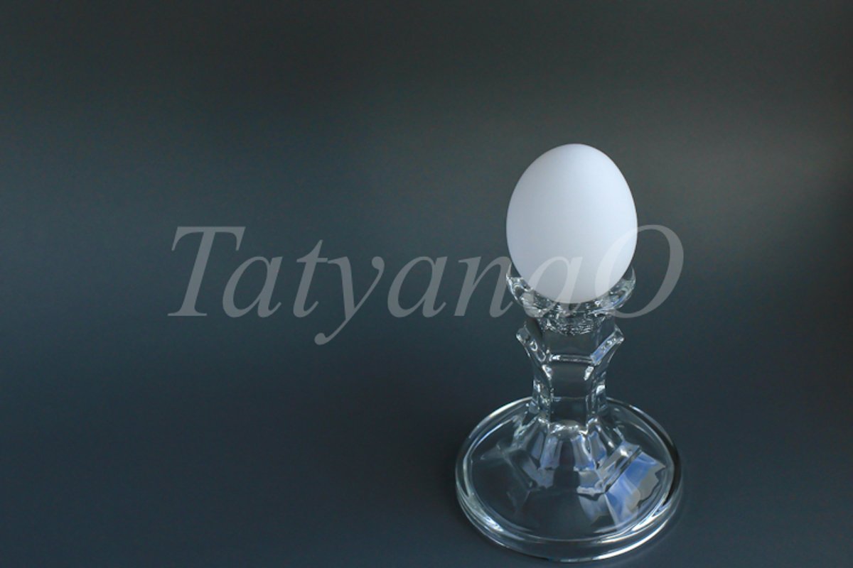 A white chicken egg in a vintage classic glass candlestick example image 1