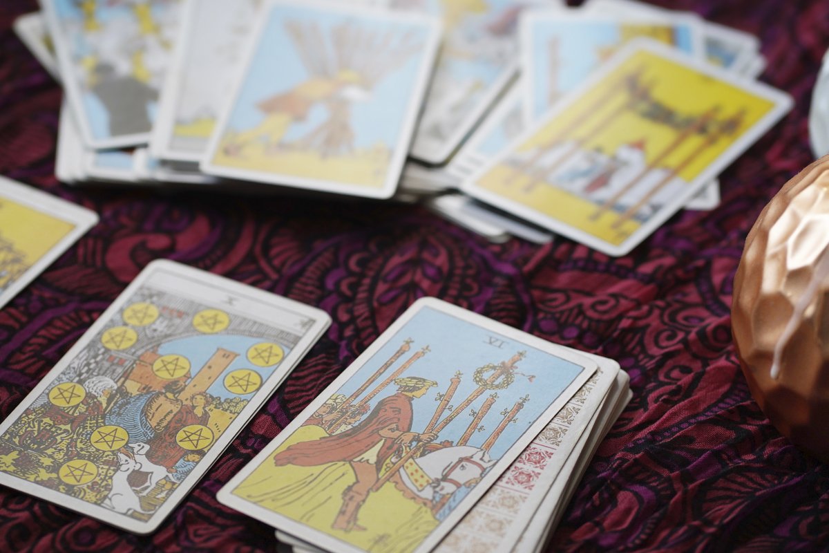 Tarot cards on table near burning candles, esoteric concept example image 1