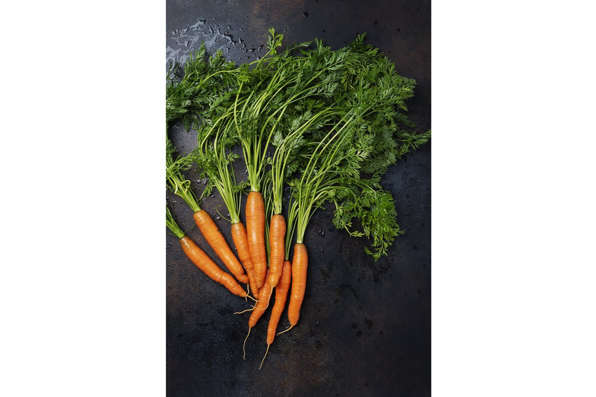 Fresh carrots with green leaves on the dark background example image 1