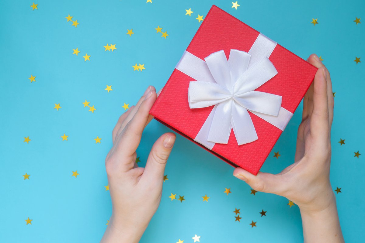Woman opening red gift box on color blue background. example image 1