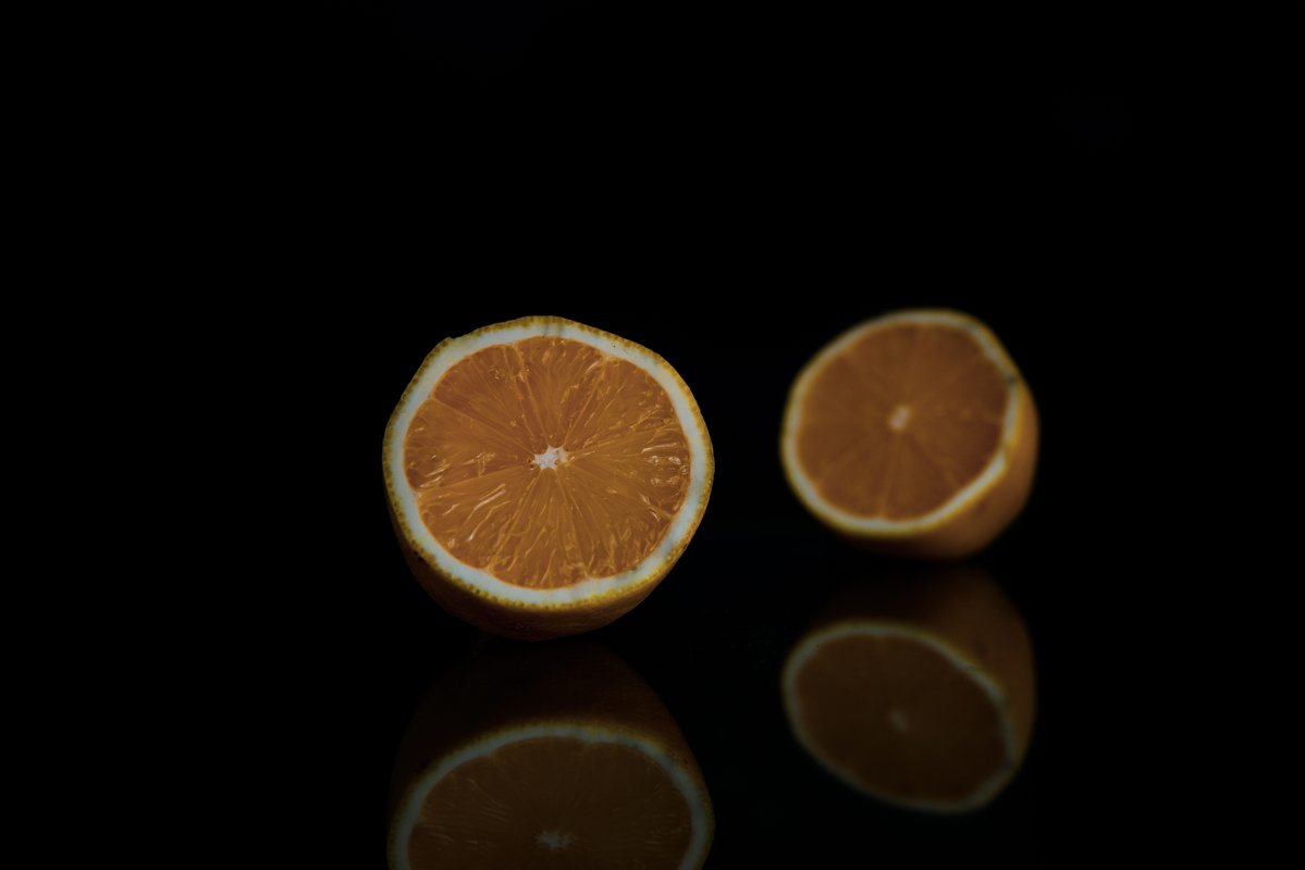 two halves of whole lemon on a black background example image 1