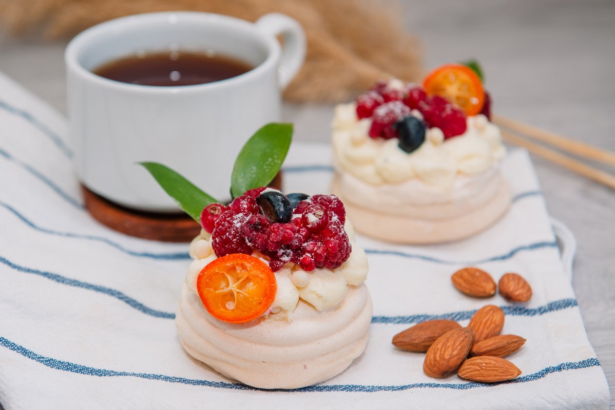 Pavlova meringue desert cake with cream and small fruits example image 1