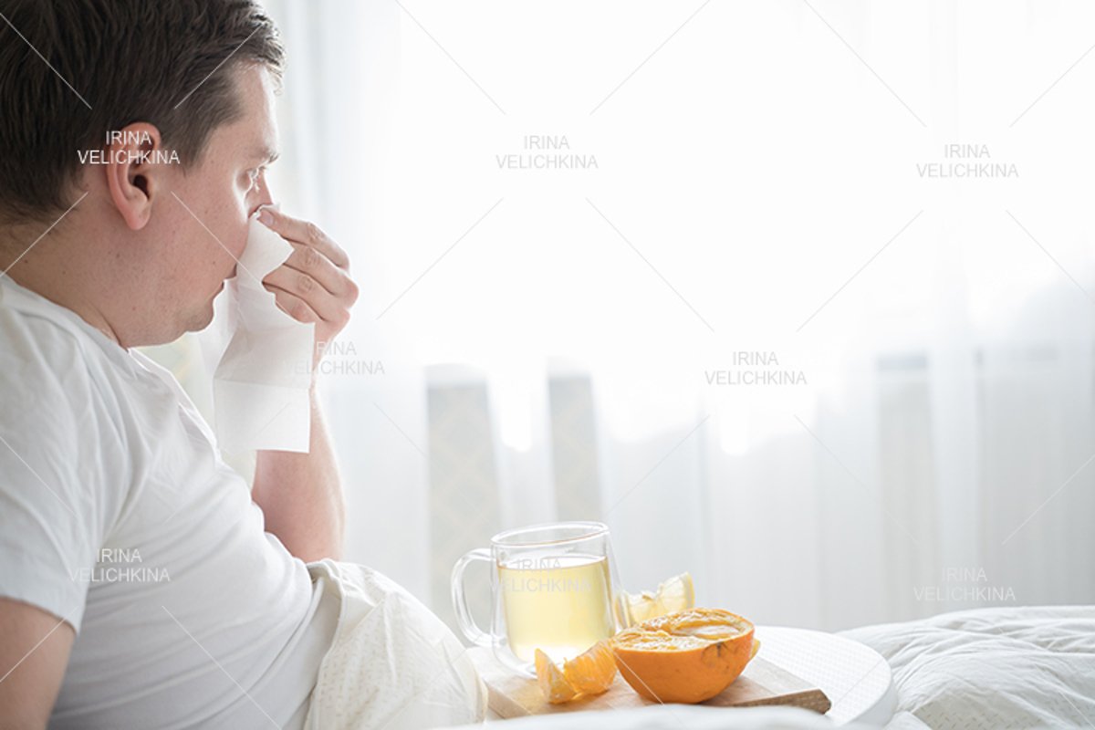 Sick man in bed. Cup of flu drugs. Tea, orange,lemon,ginger example image 1