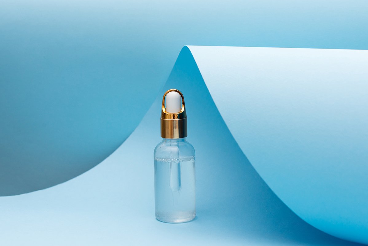 cosmetic oil bottle with pipette standing on blue background example image 1