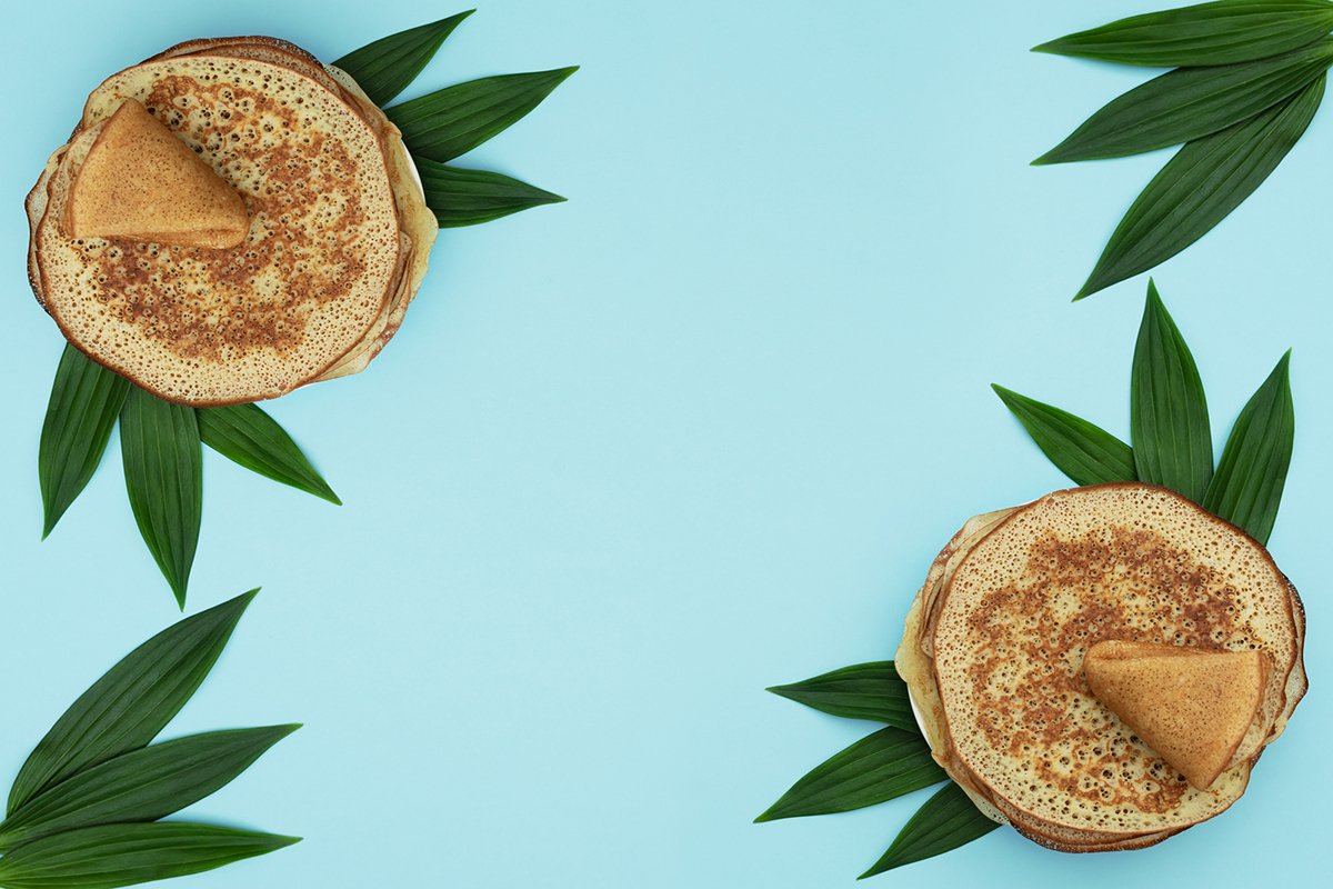 Homemade pancakes on blue background with green leaves example image 1