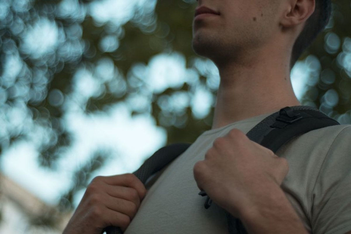 Young caucasian man walks in a park with backpack example image 1