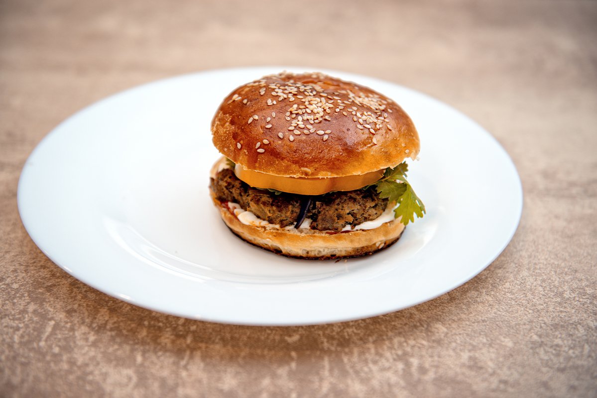 Homemade hamburger with fresh vegetables on white plate example image 1
