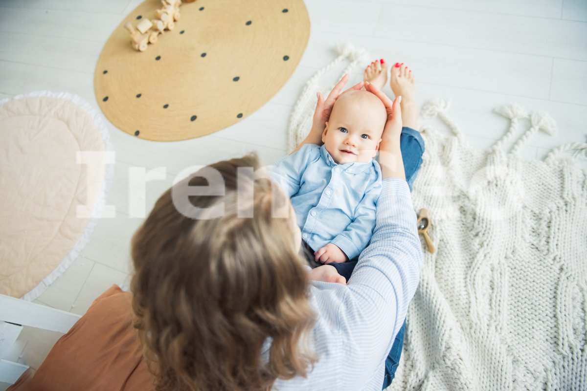 Happy baby boy under 1 year old lying on mother hands example image 1