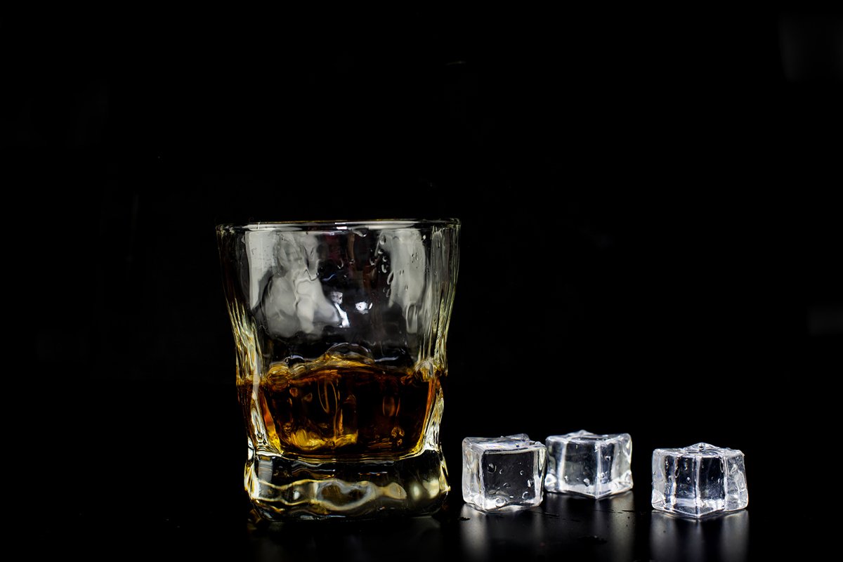 alcohol drink whiskey with ice cubes on a black background example image 1
