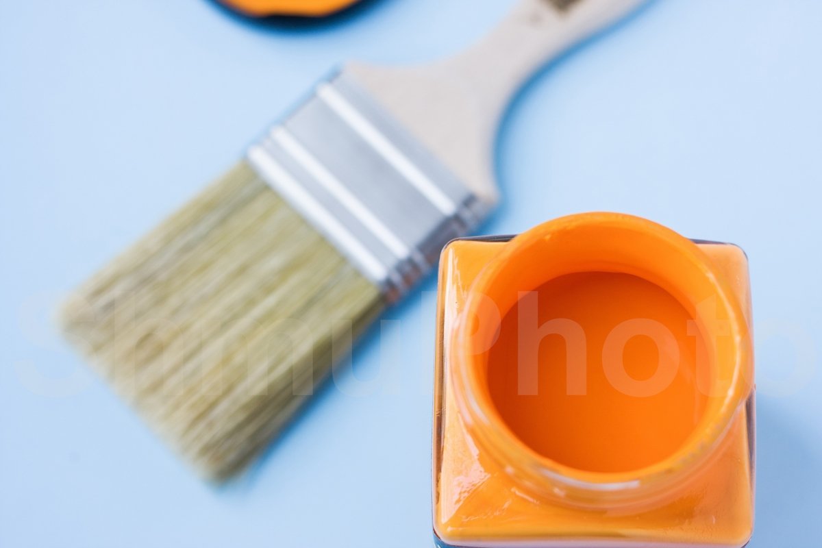 Glass can with orange paint against new brush on blue example image 1