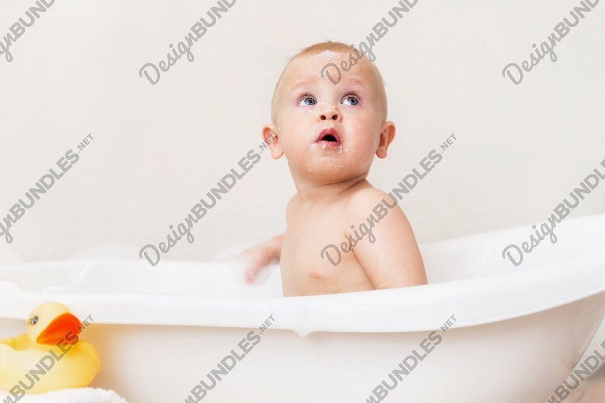 Photo of a Child is seating in the bathroom with soap foam example image 1
