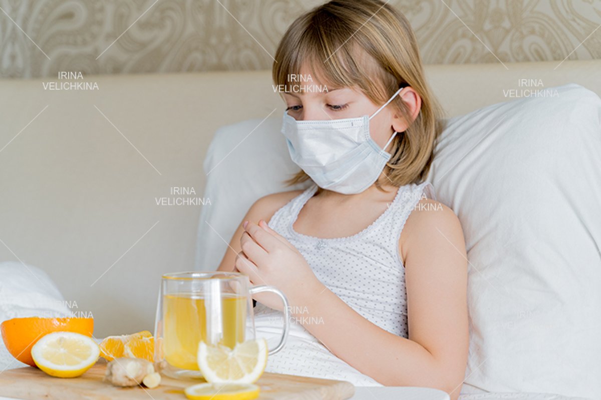 Sick girl in bed. Face mask.Cup of tea, orange,lemon,ginger example image 1