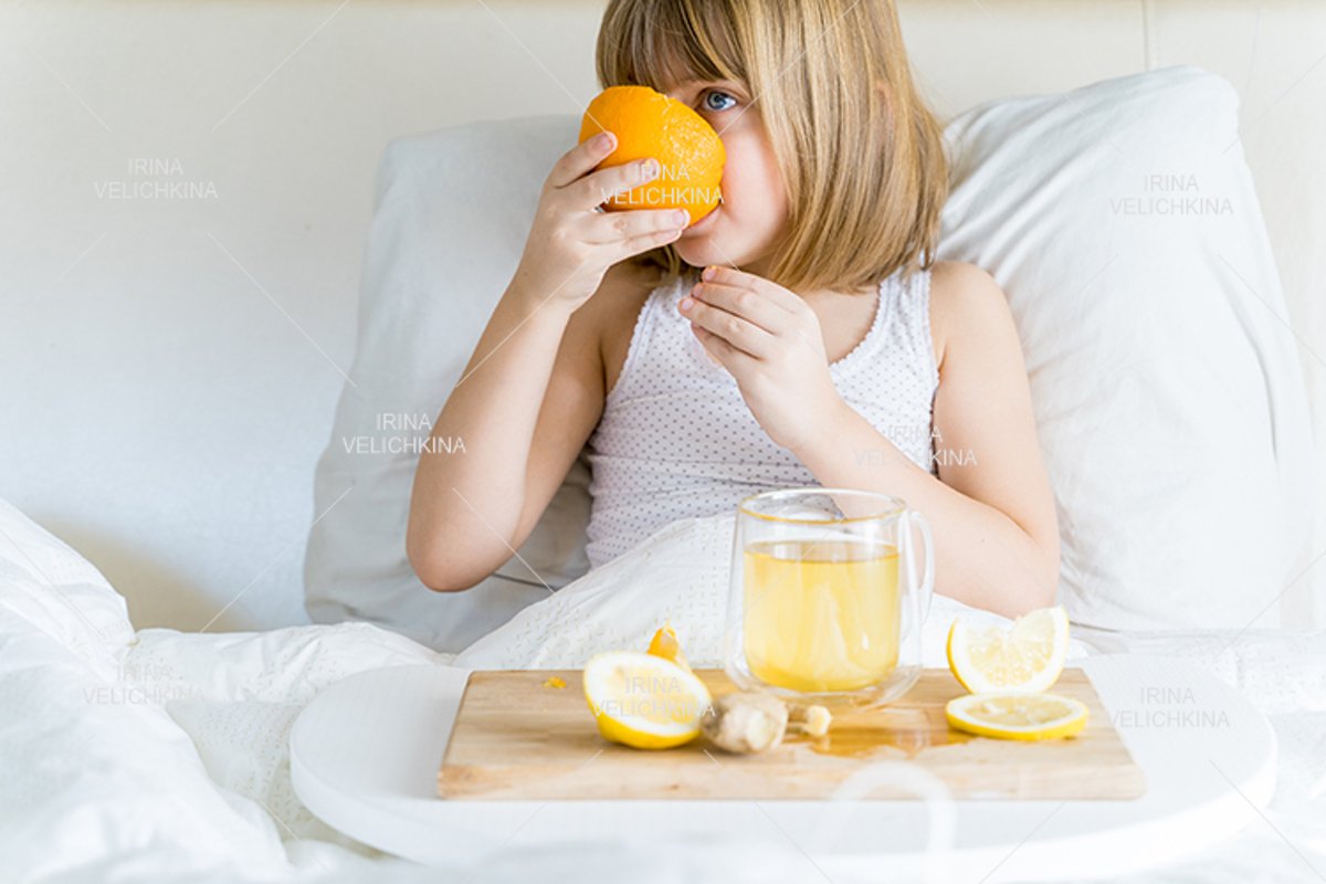 Sick girl in bed. Cup of flu drugs. Tea, orange,lemon,ginger example image 1