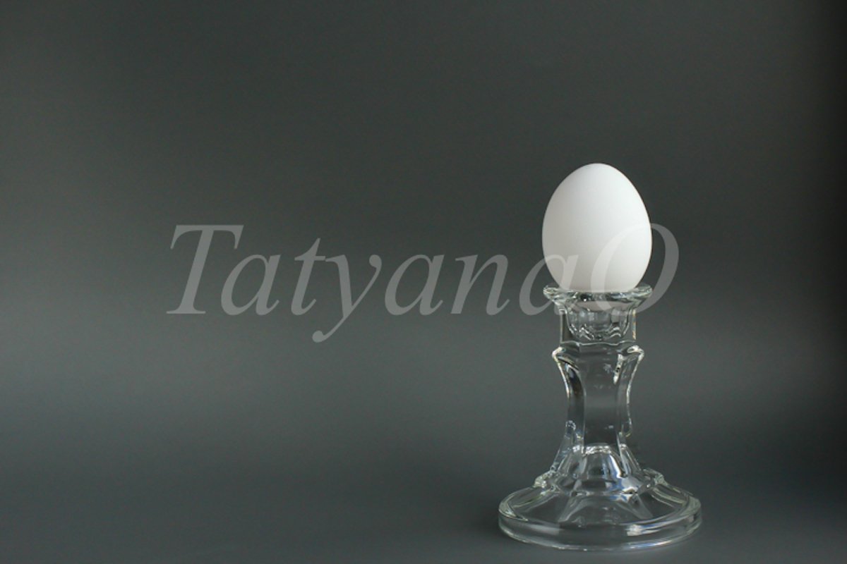 A white chicken egg in a vintage classic glass candlestick example image 1