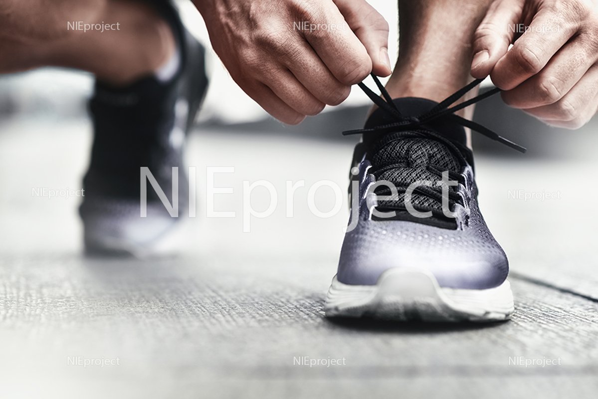 athlete tying his shoelaces at sports sneakers example image 1