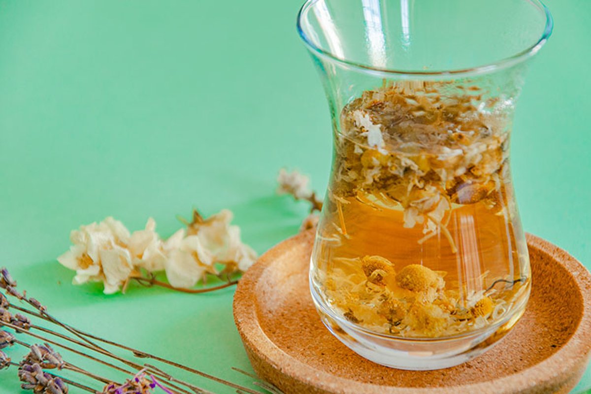 Cup of herbal tea with chamomile flowers. example image 1