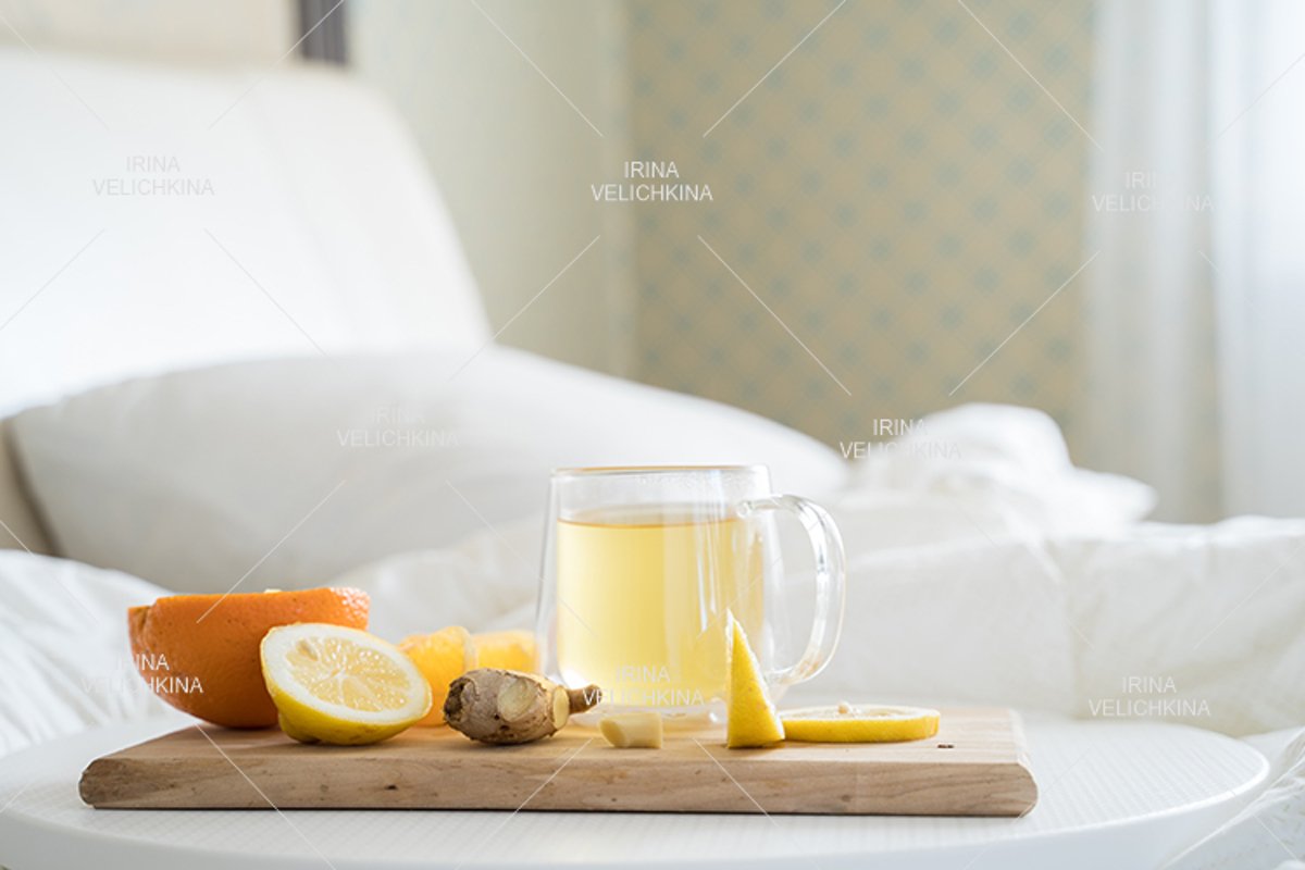 Cup of tea,orange,lemon,ginger in bed.Self treatment for flu example image 1