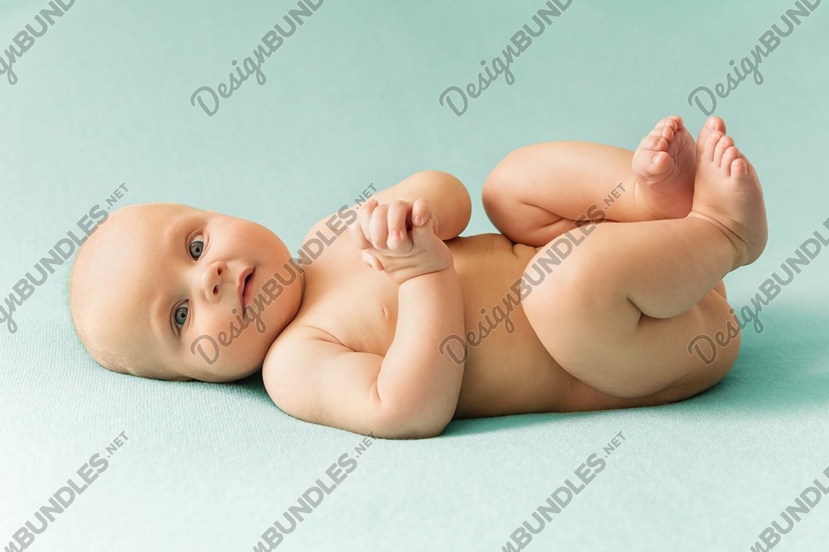 Little cute baby lies on light green background example image 1