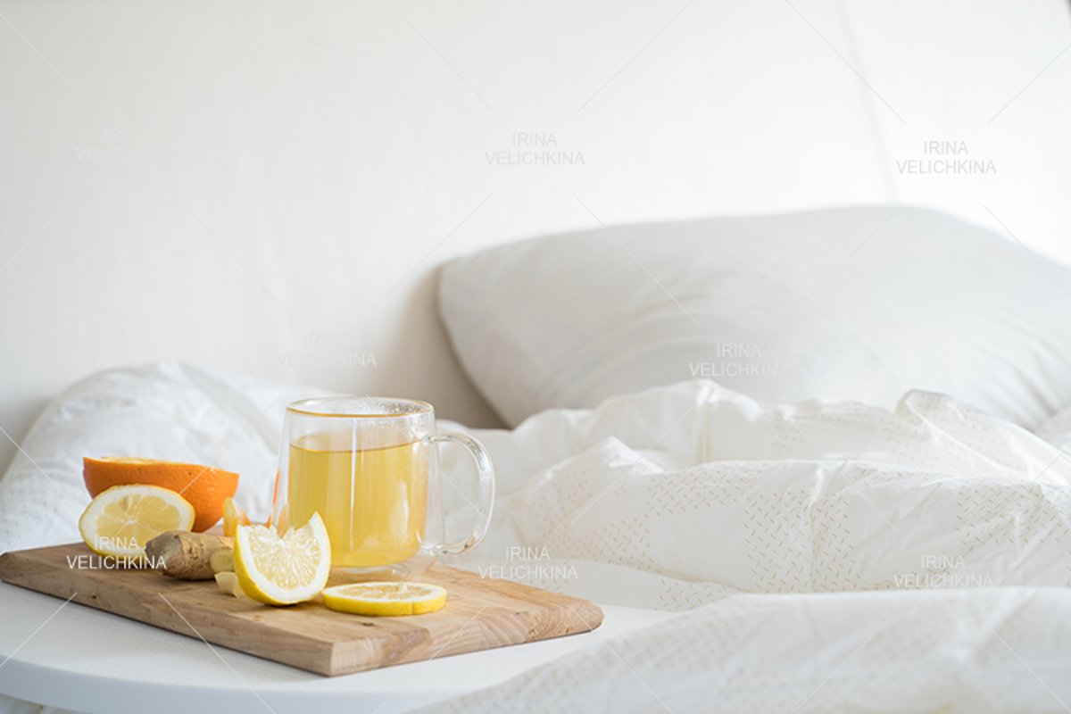 Cup of tea,orange,lemon,ginger in bed.Self treatment for flu example image 1