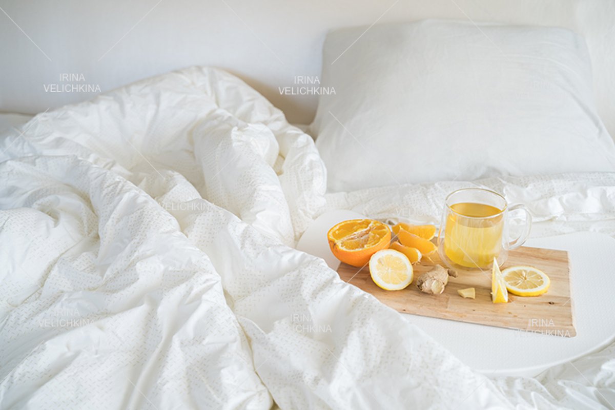 Cup of tea,orange,lemon,ginger in bed.Self treatment for flu example image 1