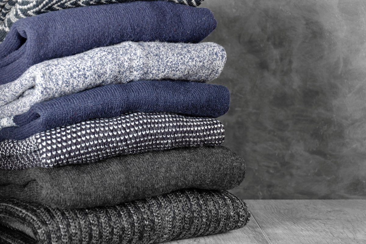 Stack of folded warm knitted men's sweaters example image 1