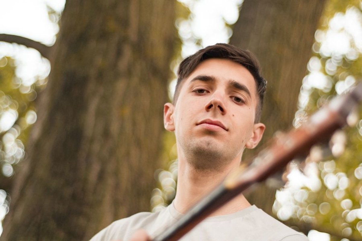 Man plays on acoustic guitar in park example image 1