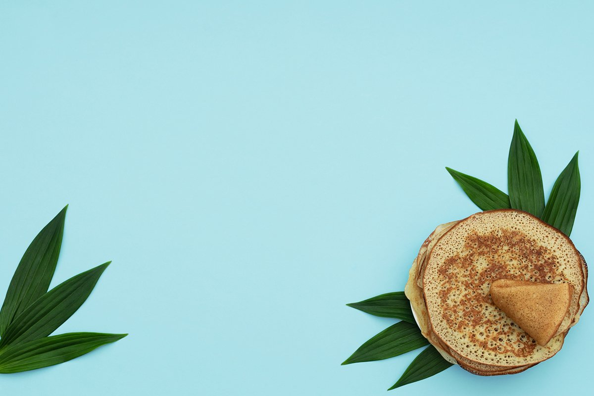 Homemade pancakes on blue background with green leaves example image 1