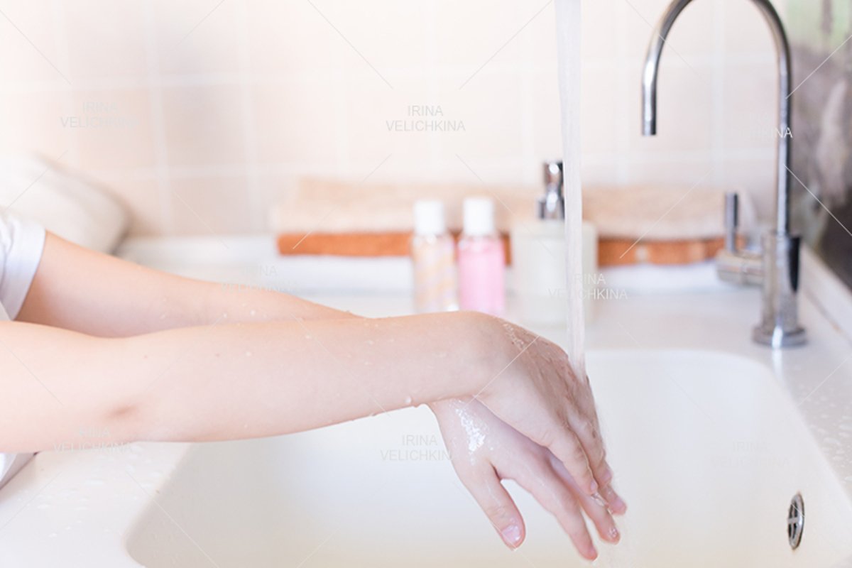 Girls wash their hands in the sink with soap in the foam example image 1