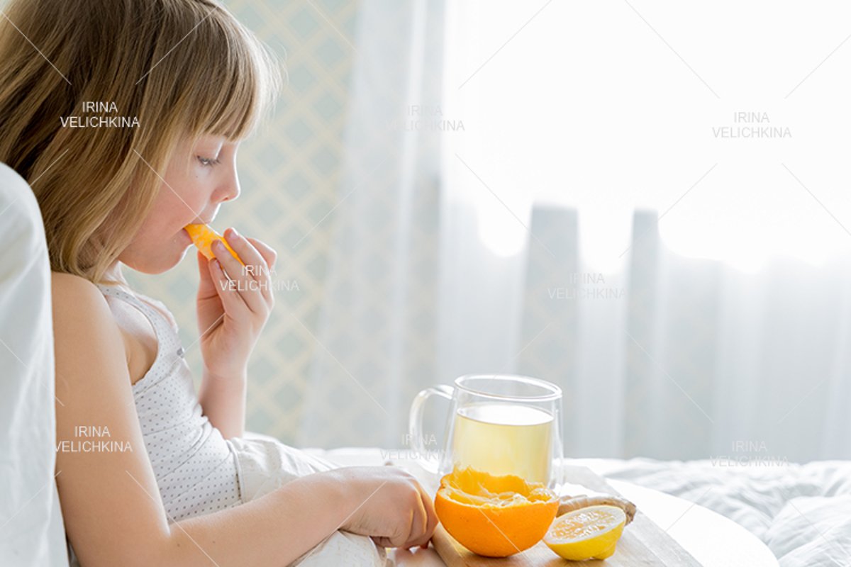 Sick girl in bed. Cup of flu drugs. Tea, orange,lemon,ginger example image 1