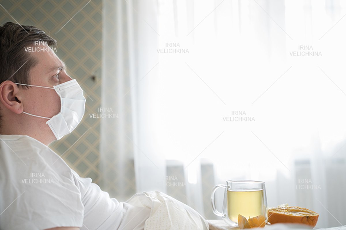 Sick man in bed. Face mask. Cup of tea, orange,lemon,ginger example image 1