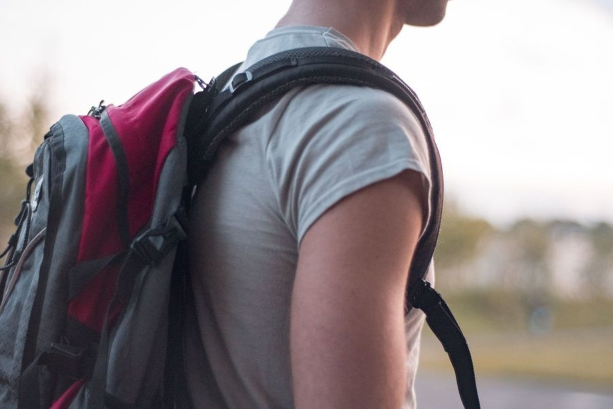 Young caucasian man walks in a park with backpack example image 1