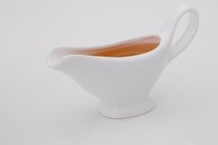 Sauce in white gravy boat on a white background Product Image 1