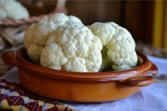 Fresh cauliflower in ceramic bowl on kitchen table Product Image 1