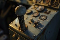 Control lever rising from metal control panel with gauges Product Image 1