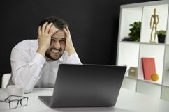 Depressed handsome freelancer sitting at desk in front Product Image 1