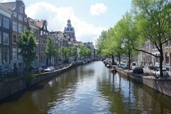 Canal reflecting traditional houses and lush green trees in Product Image 1