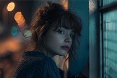 Pensive young woman by the window at night Product Image 1