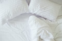 Top view of messy bedding sheets and pillows. Product Image 1