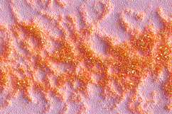 Surface covered in orange glitter on a pink background Product Image 1