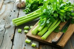 Fresh celery stalks laying on rustic cutting board Product Image 1