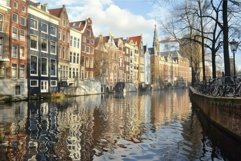 Amsterdam canal reflecting colorful houses on sunny day Product Image 1