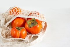 Persimmon close-up of a mesh shopping bag. Product Image 1